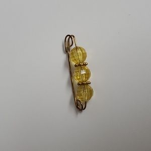 Giant clip brooch with light amber colored faceted plastic beads